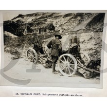 Press photo , WW1 Western front , British soldier checks German mortars 
