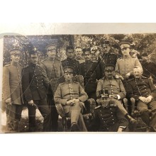 Foto groep officieren zittend voor bossen 1915